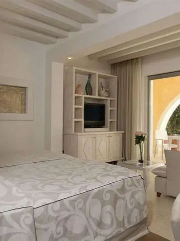 Helles Zimmer mit eleganter Dekoration und Zugang zu einer sonnigen Terrasse