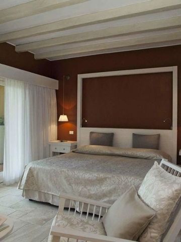 Komfortables Schlafzimmer mit direktem Zugang zum Balkon im Forte Village Resort.