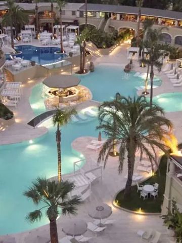 Luxuriöser Poolbereich mit Palmen bei Nacht im Forte Village Resort