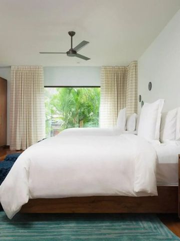 Geräumiges Zimmer mit zwei Doppelbetten und grüner Aussicht.