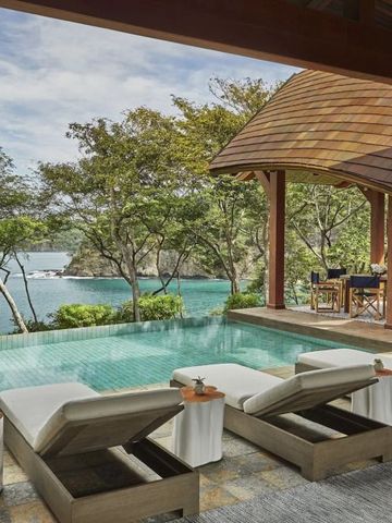 Private Terrasse mit Pool und Meerblick, umgeben von tropischen Bäumen