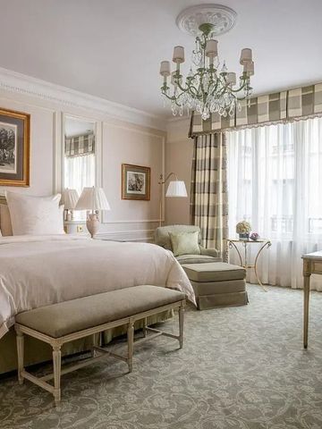 Helles Hotelzimmer mit großen Fenstern und stilvollem Interieur.