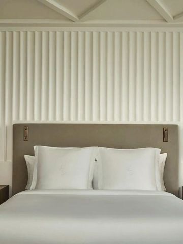 Komfortables Bett mit stilvoller Wanddekoration im Four Seasons Hotel.