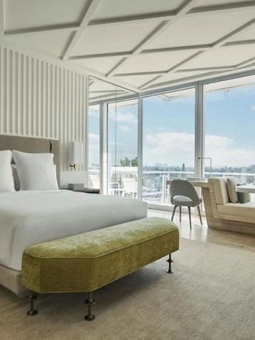 Luxuriöses Schlafzimmer mit großem Bett und Zugang zu einem privaten Balkon