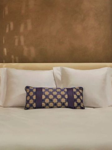 Elegantes Bett mit dekorativem Kissen in einem Hotelzimmer