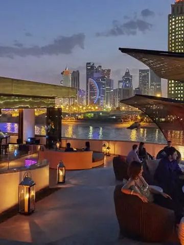 Nachtblick auf eine stilvolle Bar mit Hintergrundbeleuchtung und Skyline