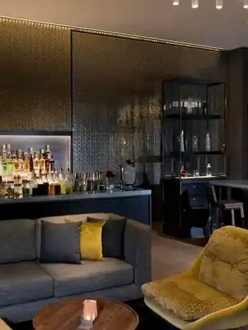 Elegante Bar mit moderner Einrichtung, beleuchtet durch dezente Kronleuchter.