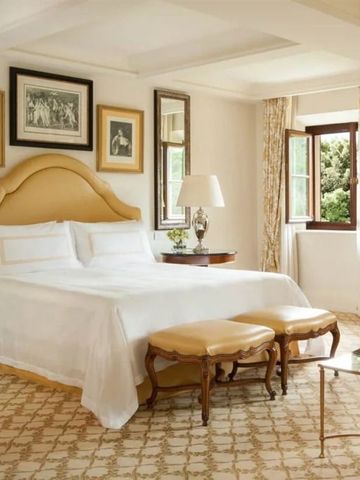 Geräumiges Zimmer mit gemütlichem Bett und Blick auf grüne Gärten