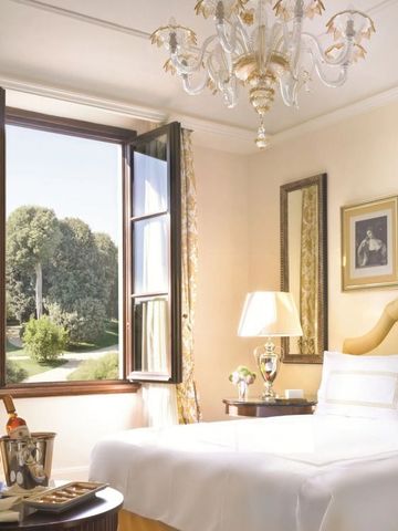 Helles Schlafzimmer mit offenem Fenster und Aussicht auf gepflegte Gärten