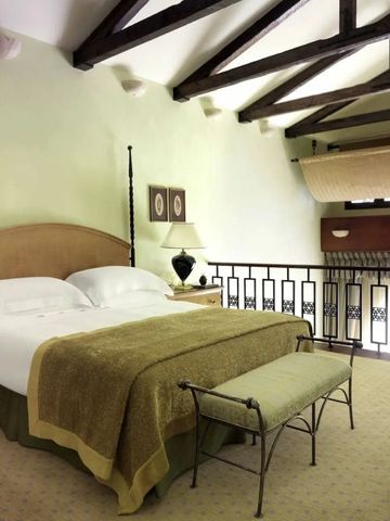 Gemütliches Schlafzimmer mit Holzbalken und Balkonblick