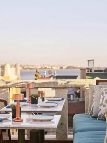 Rooftop-Terrasse mit Blick auf die Stadt und stilvoller Möblierung.