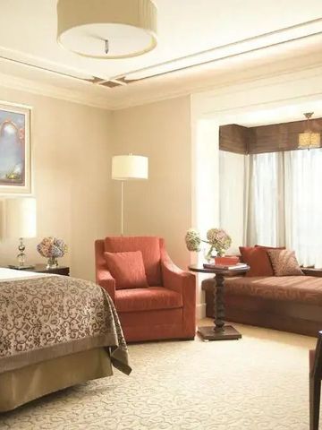 Geräumiges Hoteldoppelzimmer mit stilvollen Möbeln und gemütlicher Sitzecke.