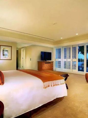 Geräumiges Schlafzimmer mit großen Fenstern und moderner Einrichtung