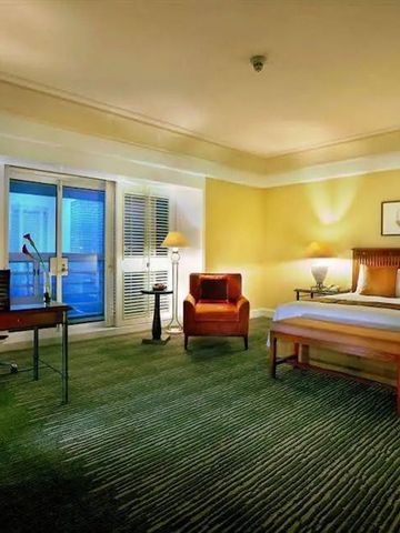 Suite mit Arbeitsbereich und gemütlichem Bett in harmonischer Farbgebung