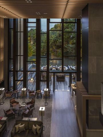 Großzügige Lobby mit hohen Fenstern und edler Einrichtung.