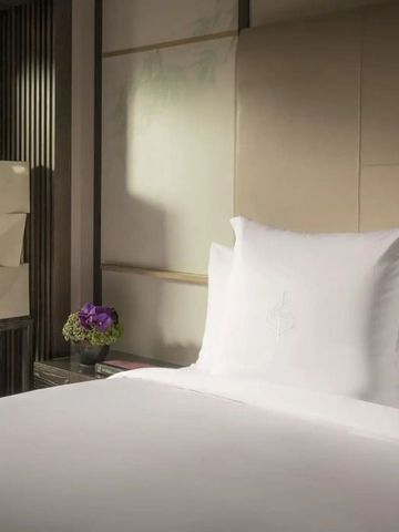 Detailansicht eines stilvollen Bettes mit lila Akzenten.