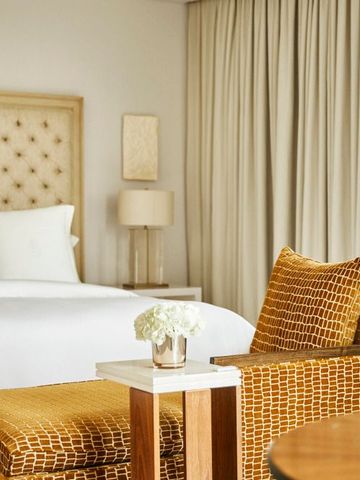 Schlafzimmer mit Designerstuhl und schicken Dekorationen