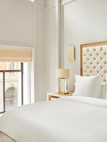 Luxuriöses Schlafzimmer mit hochwertiger Bettwäsche und hoher Decke