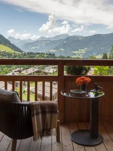 Holzbalkon mit Panoramablick auf die Alpen und gemütlicher Sitzgelegenheit.