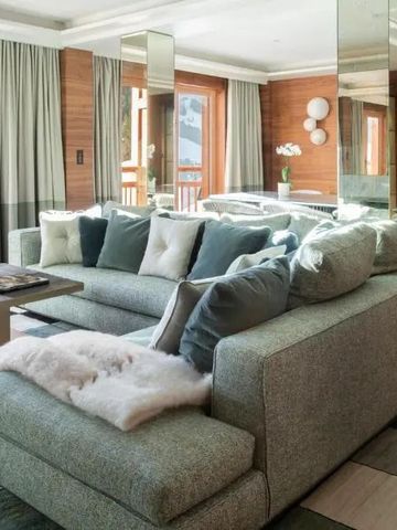 Gemütliche Lounge mit großen Sofas und vielen Kissen in einem eleganten Chalet.