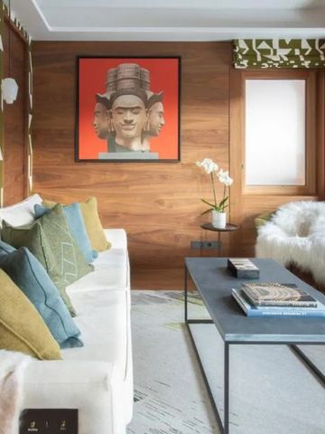 Modernes Wohnzimmer mit künstlerisch gestalteter Wand und bequemer Sitzecke.