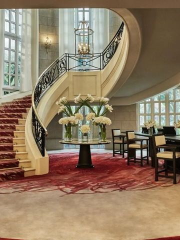 Große Lobby mit geschwungener Treppe und eleganten Sitzgelegenheiten