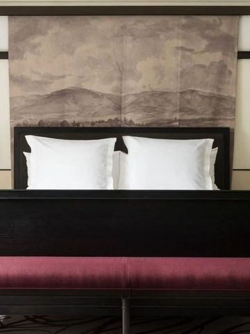 Elegantes Hotelzimmer mit modernem Dekor und minimalistischer Kunst über dem Bett