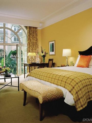 Luxuriöses Zimmer mit großen Fenstern und Blick auf einen Innenhof