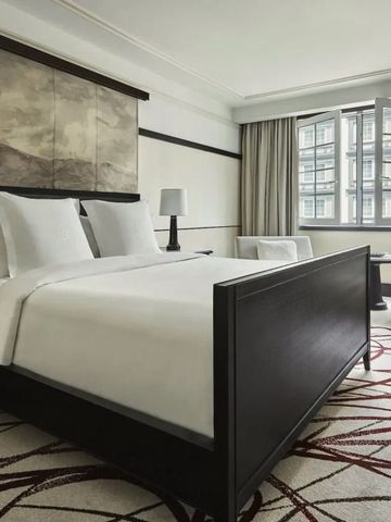 Modern eingerichtetes Schlafzimmer mit großen Fenstern und viel Licht