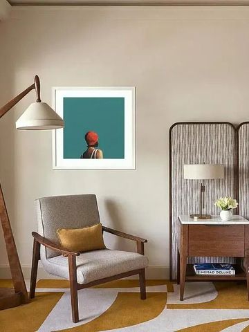 Modernes Sitzbereich im Hotelzimmer mit stilvoller Lampe und minimalistischem Kunstwerk