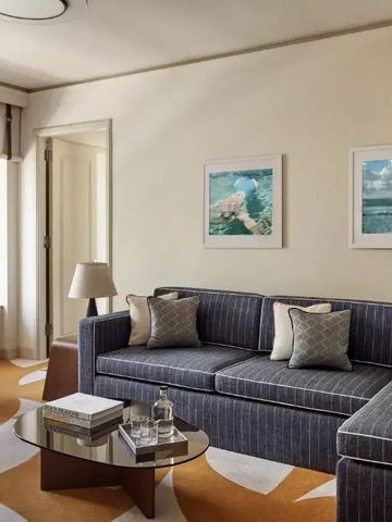 Geräumiger Wohnbereich im Hotelzimmer mit bequemen Sofas und elegantem Tisch