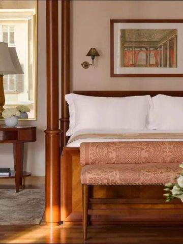 Elegantes Hotelzimmer mit Holz- und Beigetönen, Kingsize-Bett und kunstvoll eingerichteter Ecke