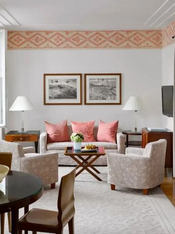 Helles Wohnzimmer mit eleganter Einrichtung und großen Fenstern im luxuriösen Hotelzimmer