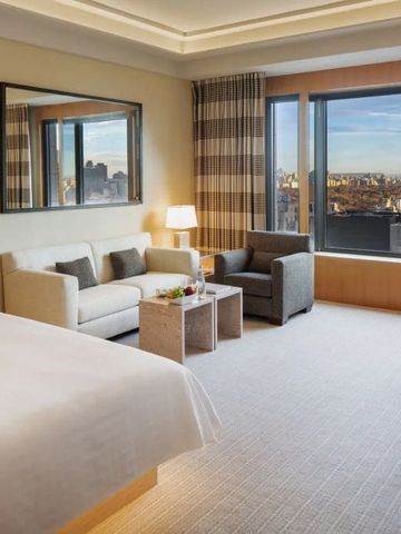 Helles Zimmer mit Sofa und Panoramafenstern über die Stadt