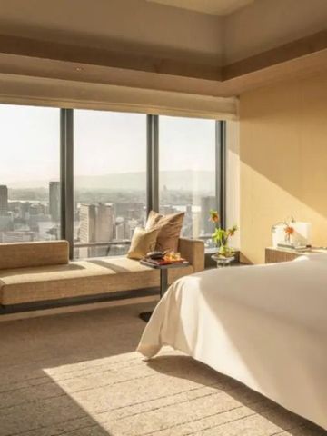 Helles Hotelzimmer mit Panoramafenster und Stadtblick im Four Seasons Osaka