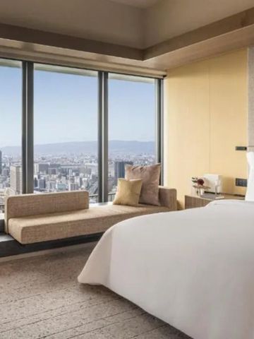 Luxuriöses Gästezimmer mit großer Fensterfront und Stadtblick