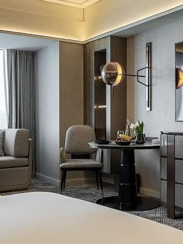 Modernes Hotelzimmer mit Sitzbereich und großen Fenstern im Four Seasons Hotel Riyadh.