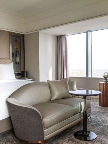 Geräumiges Schlafzimmer mit Sitzbereich und großem Fenster