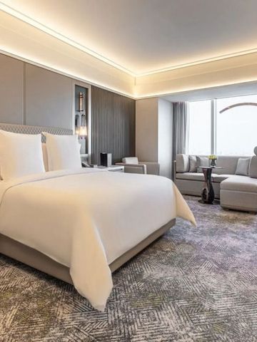 Modernes Hotelzimmer mit großem Bett und gemütlicher Sitzecke