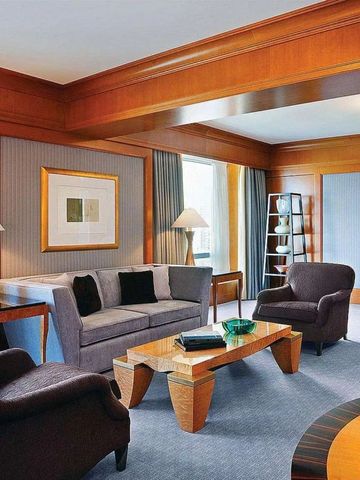 Wohnzimmer einer Suite mit eleganten Möbeln und Holzakzenten