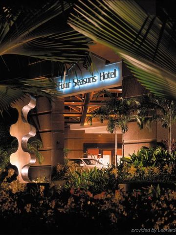 Hoteleingang bei Nacht umgeben von tropischer Vegetation