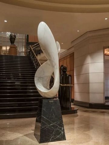 Elegante Lobby mit imposanter Kunstskulptur und Treppen