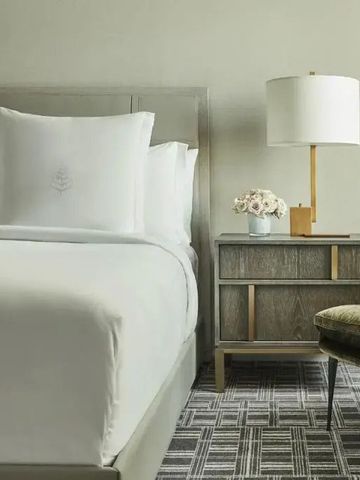 Detailansicht eines Bettes mit Nachttisch und Lampe