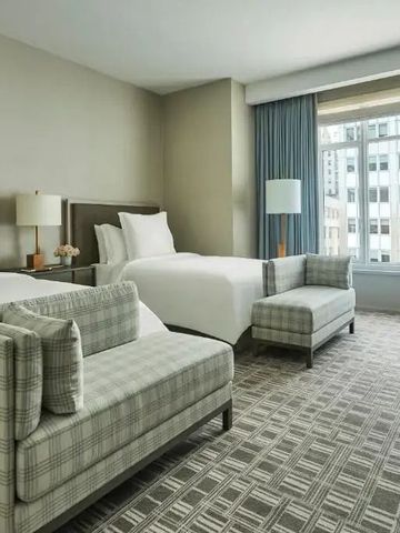 Doppelzimmer mit zwei Betten und großen Fenstern im Hotel