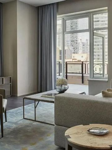 Geräumige Luxussuite mit modernem Wohnbereich und Zugang zu einem großen Fenster mit Stadtblick