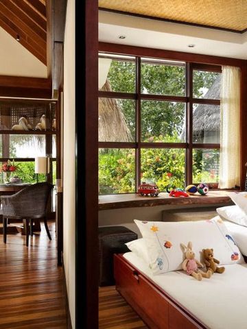 Geräumiges Zimmer mit Blick auf tropische Gärten und stilvoller Holzeinrichtung