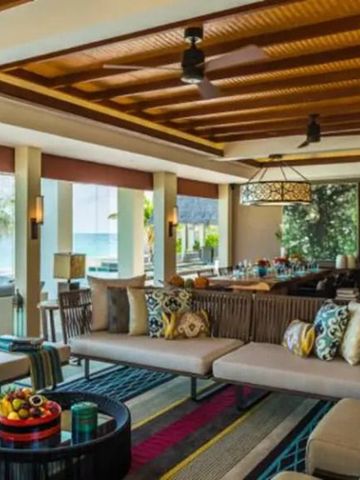 Geschmackvoll eingerichtete Lounge mit Meerblick und Holzdach