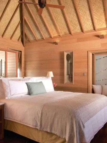 Luxuriöses Schlafzimmer mit Holzwänden und einem großen Bett