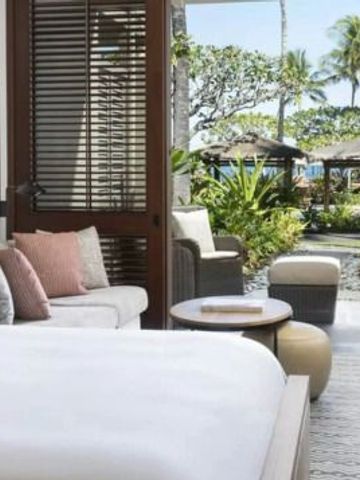 Schlafzimmer mit direktem Zugang zu einem tropischen Garten mit Palmen