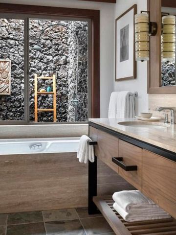 Modernes Badezimmer mit freistehender Wanne und Natursteinwand